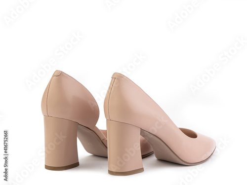 Obraz na płótnie Classic and elegant high-heeled women shoes. Stylish beige shoes on high block heels and with a pointed toe. Isolated object close up on white background. Back side view. Fashion shoes. w salonie