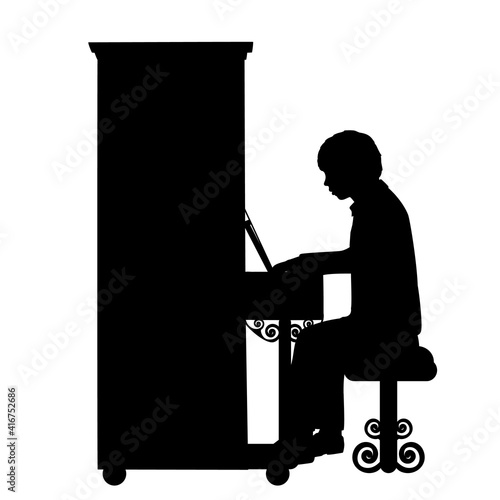 Silhouette boy music plays the piano.