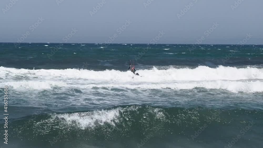 Kite surfer having fun during stormy day on waves of Ocean. Sunny day lighting. Slow motion wide shot. Kite surfer having fun during stormy day on waves of Ocean. Sunny day lighting. Slow motion wide shot.