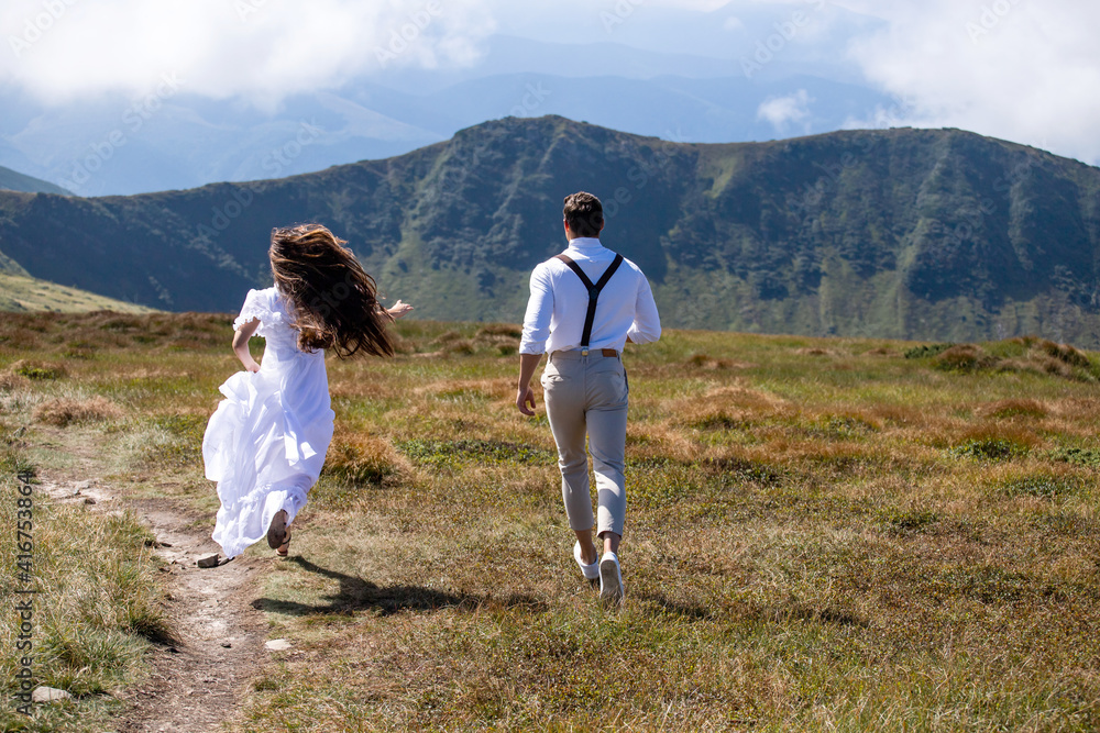 bride and groom walking in the mountains