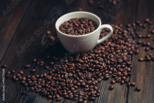 cup and saucer coffee beans on a wooden background aroma