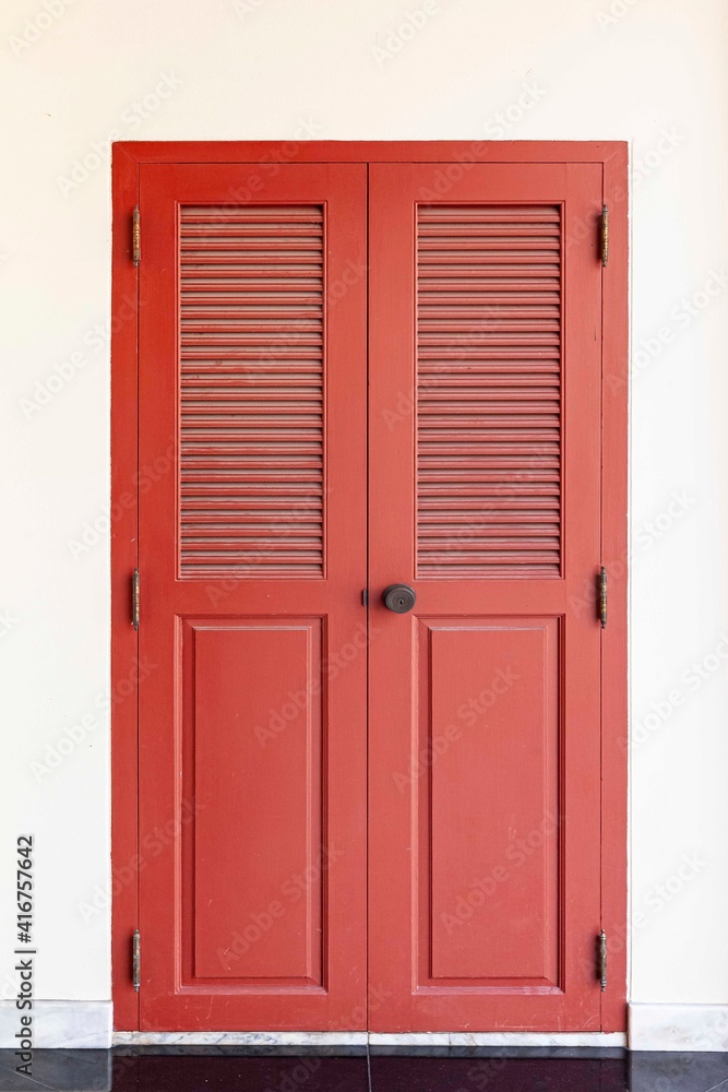 Vintage red wooden door and light cream stucco wall