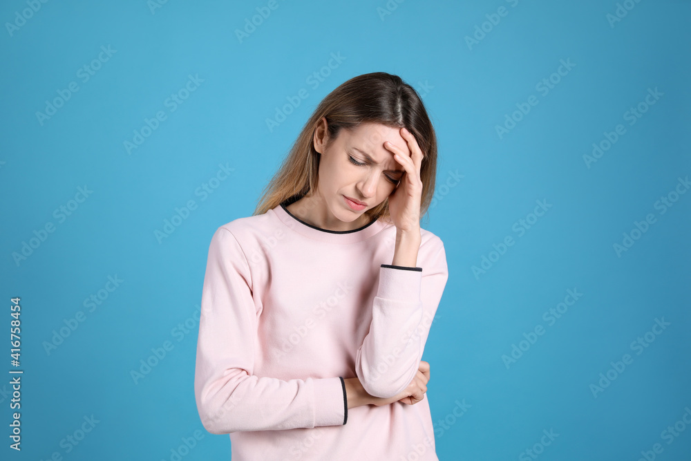 Portrait of stressed young woman on light blue background Portrait of stressed young woman on light blue background