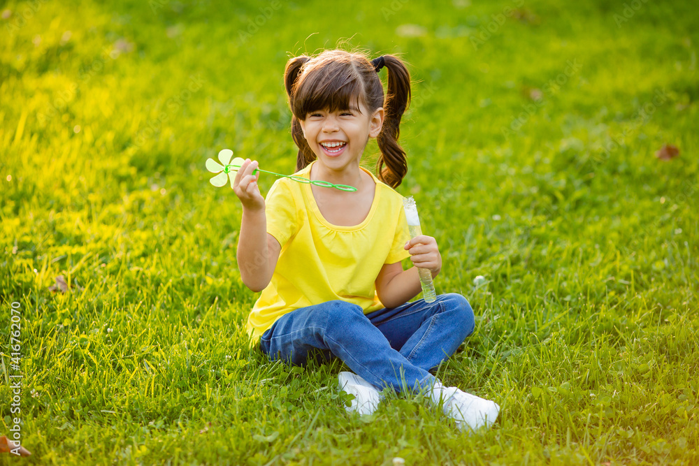 Cute little Indian girl summer on the lawn blowing soap bubbles Cute little Indian girl summer on the lawn blowing soap bubbles
