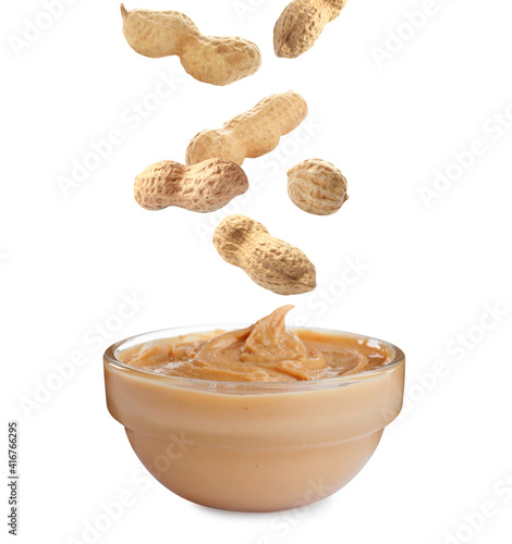 Delicious peanut butter in glass bowl on white background
