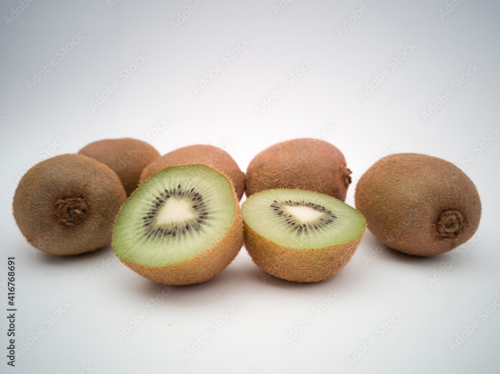 A group of kiwis on white background. Kiwi cut in half closeup. A group of kiwis on white background. Kiwi cut in half closeup.