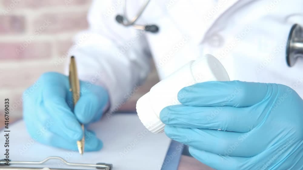 doctor hand in protective glass holding pill container doctor hand in protective glass holding pill container