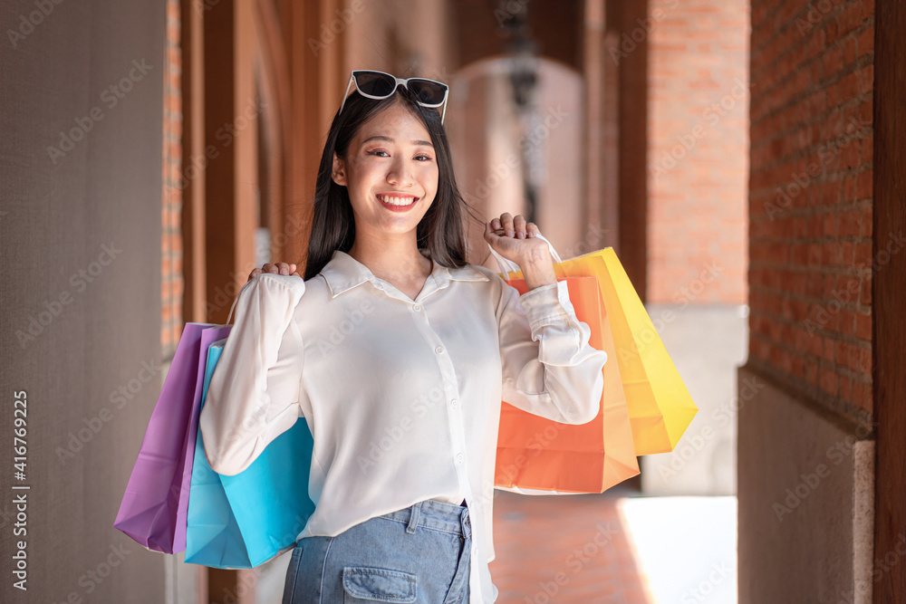 © Freedomz - Portrait of Asian girl excited beautiful girl wearing sunglasses happy smiling with holding shopping bags enjoying in shopping relaxed expression, Positive emotions shopping, lifestyle concept © Freedomz - Portrait of Asian girl excited beautiful girl wearing sunglasses happy smiling with holding shopping bags enjoying in shopping relaxed expression, Positive emotions shopping, lifestyle concept