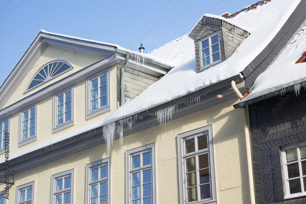 Eiszapfen hängen von Dach