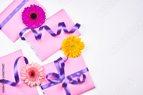 Cute spring gift boxes with daisy flowers. Spring floral background with present boxes © Golib Tolibov