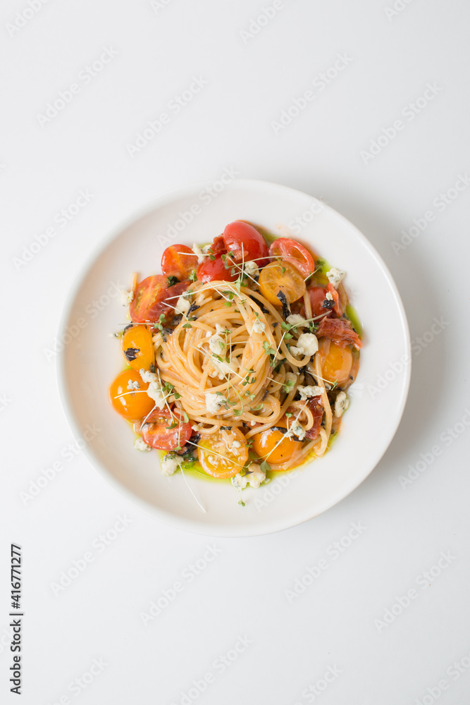 вкусная итальянская еда паста с морепродуктами красивая яркая аппетитная. украшенная маленькими помидорами черри. вертикальное фото
