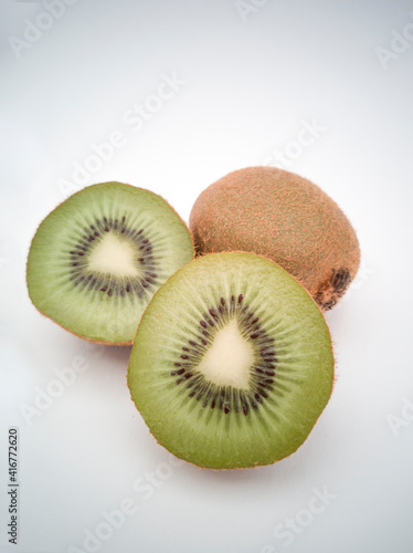 A close view on kiwi cut in half and group of kiwis on white background.