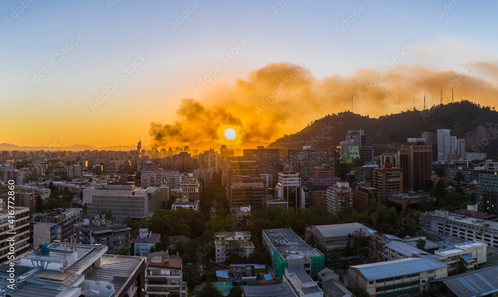 Obraz premium A bloody sky for a bloody city, A view of Santiago city skyline on fire during the protests that bring again chaos to the city, a huge smoke column rises from the looted commercial buildings