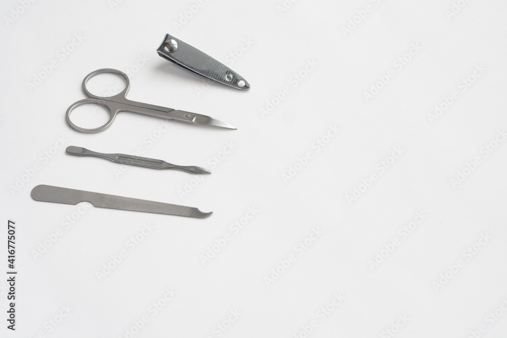 Metal manicure set, tweezers, scissors, file and spatula on white background, copy space Metal manicure set, tweezers, scissors, file and spatula on white background, copy space