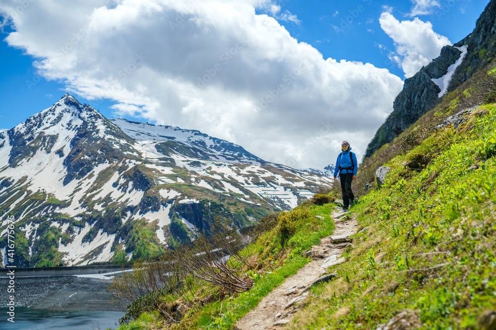 A young female hiker does trail hiking in the mountains of Gastein in Austria. A young female hiker does trail hiking in the mountains of Gastein in Austria.