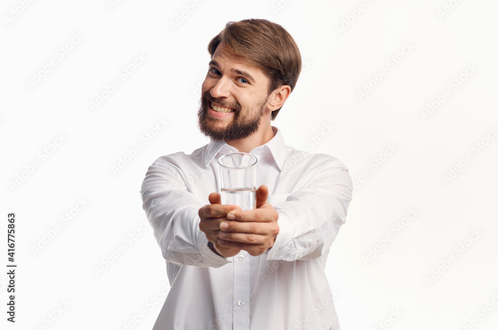 joyful man stretches out his hand with a glass of water forward on a light background joyful man stretches out his hand with a glass of water forward on a light background