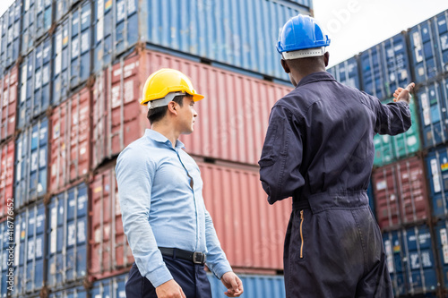 Selective focus at African black worker while talk and having discussion with supervisor and inspect the condition of all containers shipment, People and worker in freight deliver, import and export.