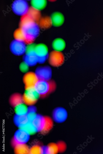Blurred multicolored background image. Circles on a black background.
