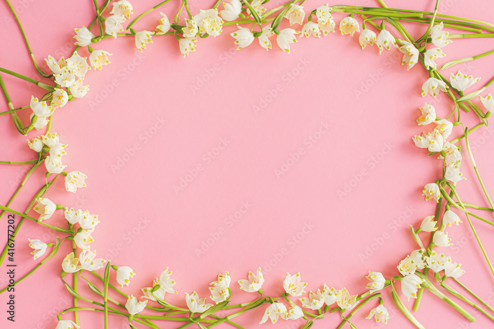 Flowers frame flat lay on pink paper. Stylish floral greeting card, space for text. Hello spring Flowers frame flat lay on pink paper. Stylish floral greeting card, space for text. Hello spring