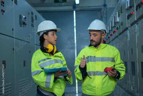 Couple worker  in electrical room. couple  engineer in electrical control room.