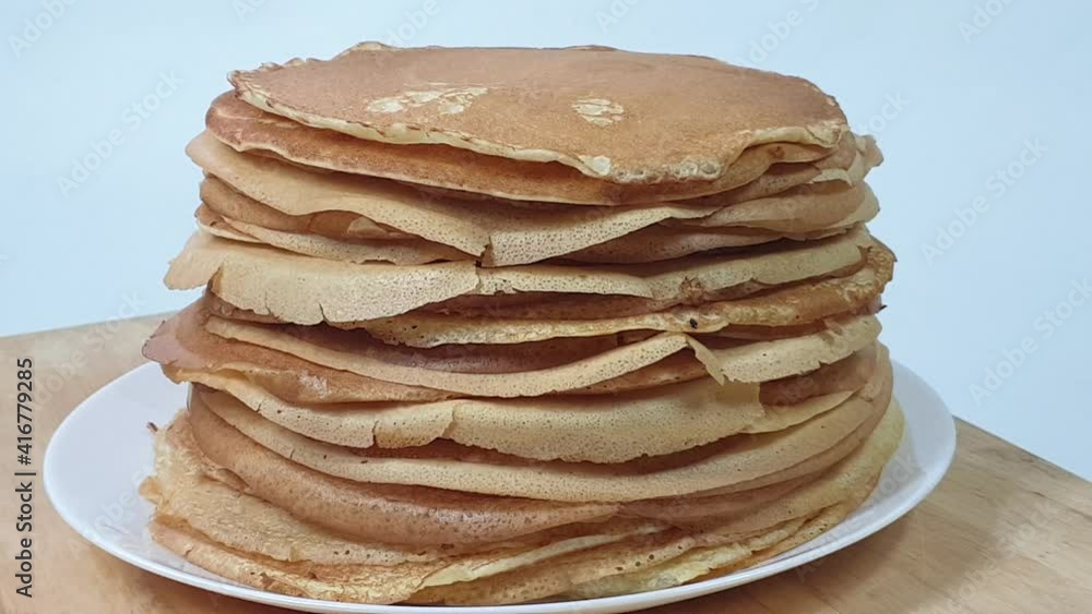 a stack of Russian pancakes on a white background on a wooden board, pancakes on Shrovetide before Lent a stack of Russian pancakes on a white background on a wooden board, pancakes on Shrovetide before Lent
