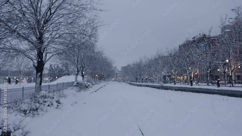 SNOW COVERED RAILROAD TRACKS ON EMPTY ROAD SNOW COVERED RAILROAD TRACKS ON EMPTY ROAD
