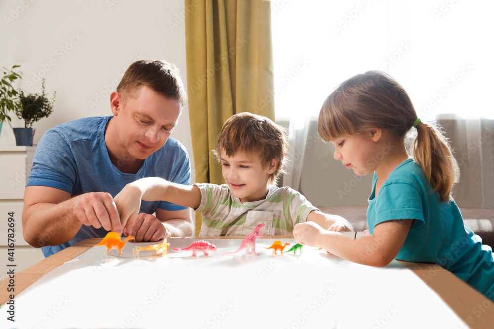 Dad with two kids playing animal figures together at home. Family having fun playing at home. stay home concept Dad with two kids playing animal figures together at home. Family having fun playing at home. stay home concept