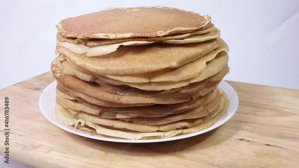 a stack of Russian pancakes on a white background on a wooden board, pancakes on Shrovetide before Lent a stack of Russian pancakes on a white background on a wooden board, pancakes on Shrovetide before Lent