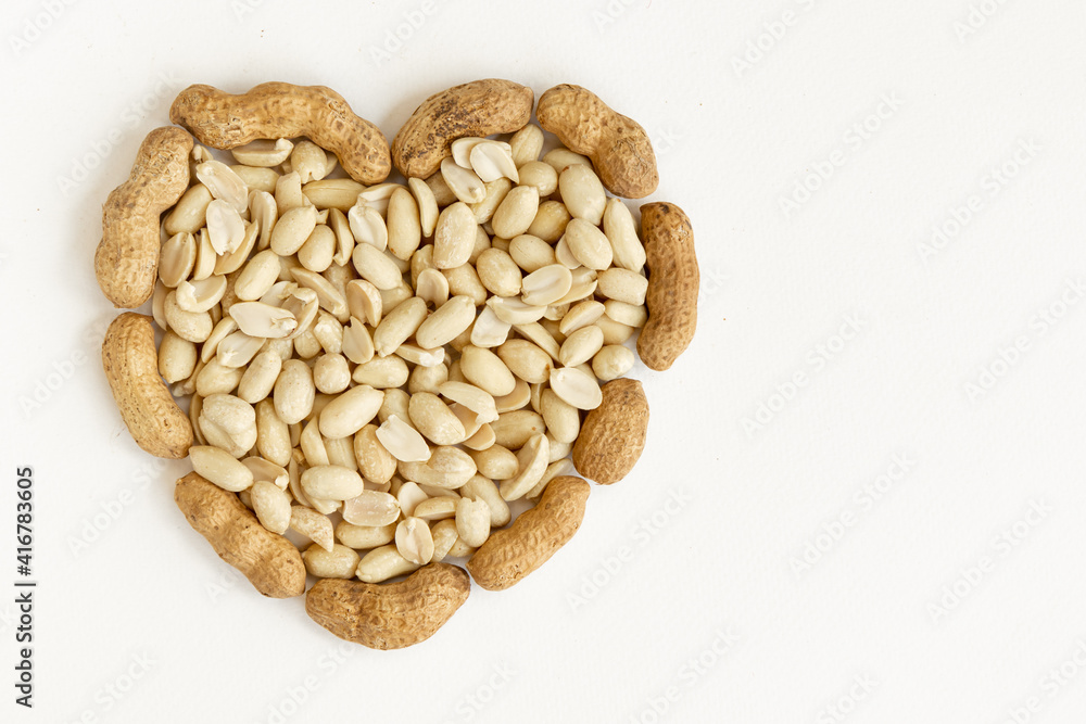 Salted peeled peanuts in a heart shape isolated on white background. Salted peeled peanuts in a heart shape isolated on white background.