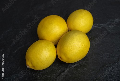 Close up photo of organic fresh lemons over black background