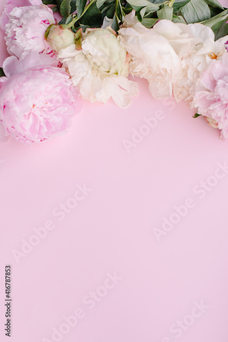 Fototapeta Naklejka Na Ścianę i Meble -  Delicate light beautiful pink background with a frame of peonies. Copy space for text. Floral border banner. Romance mothers day femininity womens day. Postcard texture spring summer peony