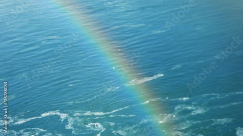 Close up of rainbow with water flowing during winter in background photo