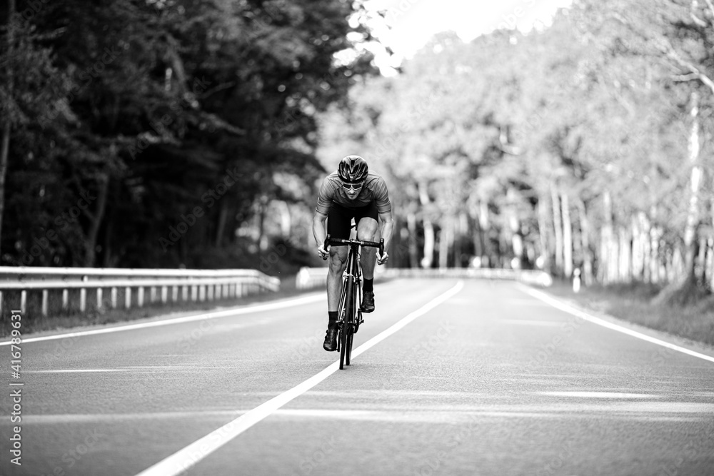 Cyclist doing sport among green forest