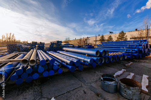 Stack of cast iron pipes in loading area waiting for transportation