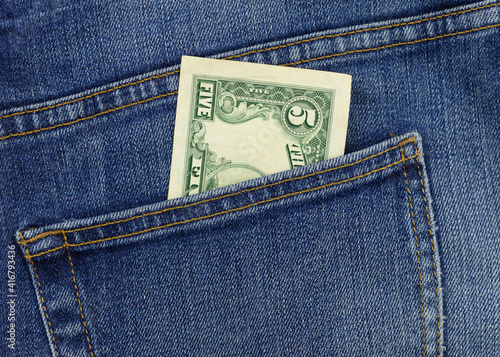 5 dollar bill in jeans pocket close-up. Pocket money concept. Cash for payment.