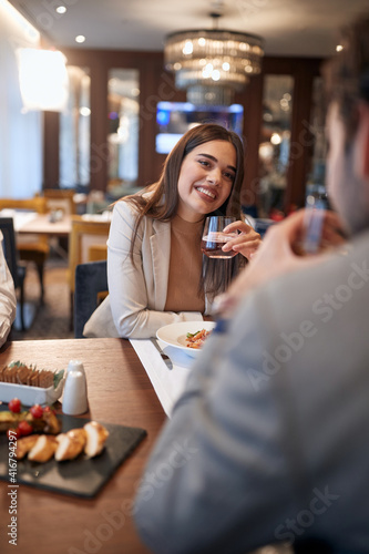 A young businesswoman talking with a male colleague at business lunch at the restaurant. Business  restaurant  lunch