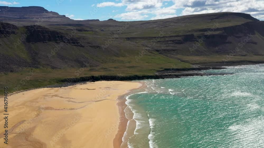 Flying over beautiful beach with tuquoise sea waves. West fjords of Iceland. Raudasandur - yellow sand beach Flying over beautiful beach with tuquoise sea waves. West fjords of Iceland. Raudasandur - yellow sand beach