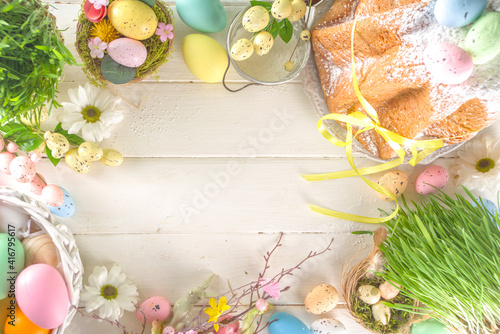 Fototapeta Naklejka Na Ścianę i Meble -  Easter sweets and decorations background, Sweet easter cake panettone with colorful painted eggs, spring grass and decor, copy space for text