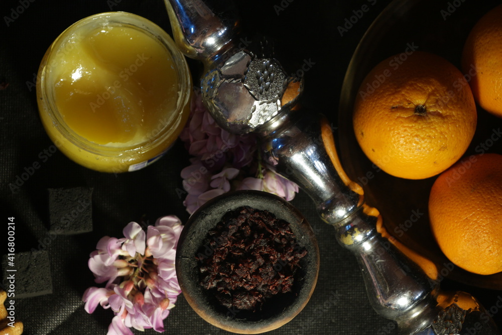 bowl with tobacco for hookah on a dark background. berries on a black table. hooka smoking bowl with tobacco for hookah on a dark background. berries on a black table. hooka smoking