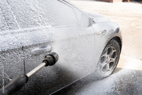 washing the car with foam from the gun