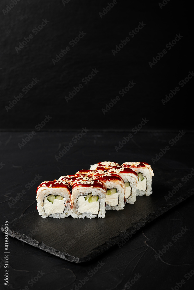 rolls on a black board on a dark textured background rolls on a black board on a dark textured background