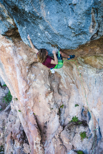 A young athlete climbs a rock