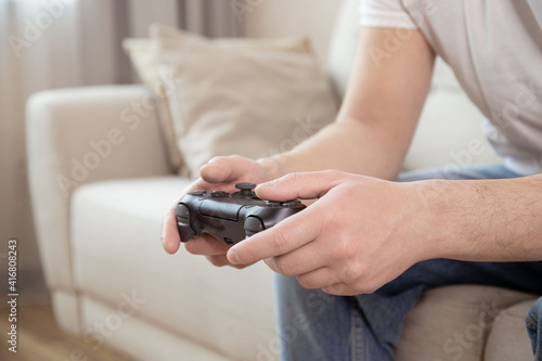 Playing games concept. Man holding joystick and play video games, close up.