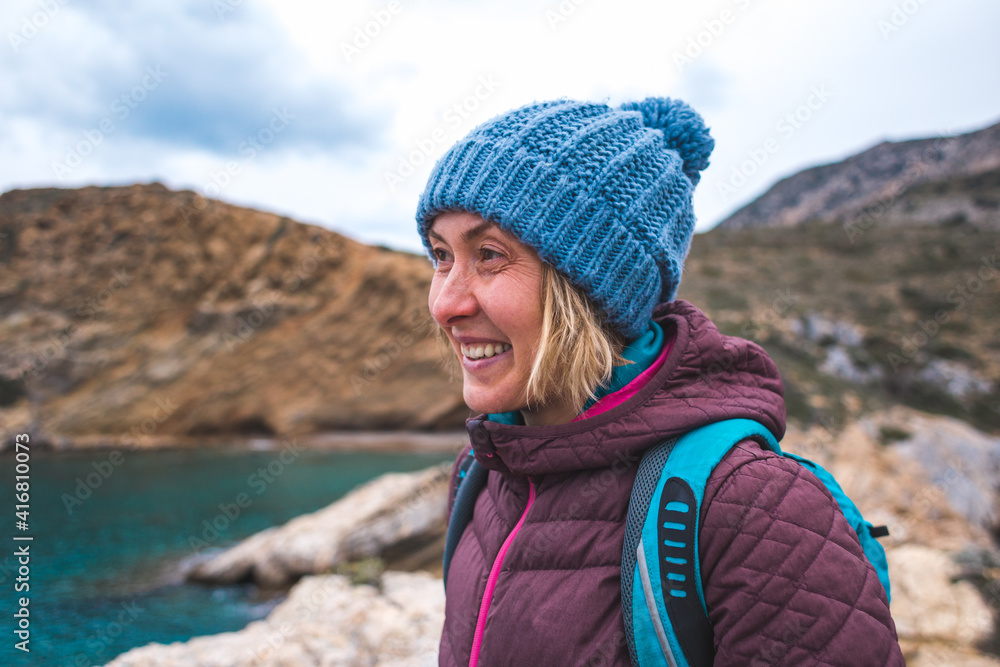 Portrait of a smiling girl in a knitted hat while walking along the sea coast Portrait of a smiling girl in a knitted hat while walking along the sea coast