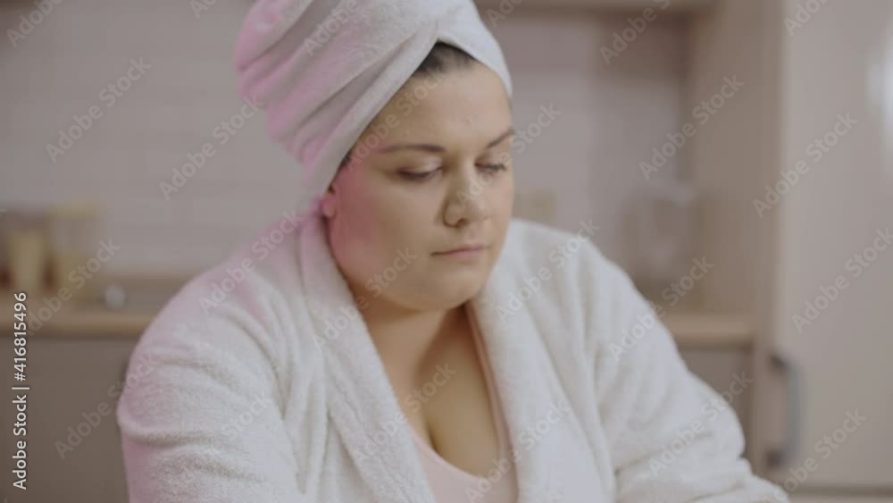 Female freelancer with towel on head typing report on laptop at home, overwork Female freelancer with towel on head typing report on laptop at home, overwork