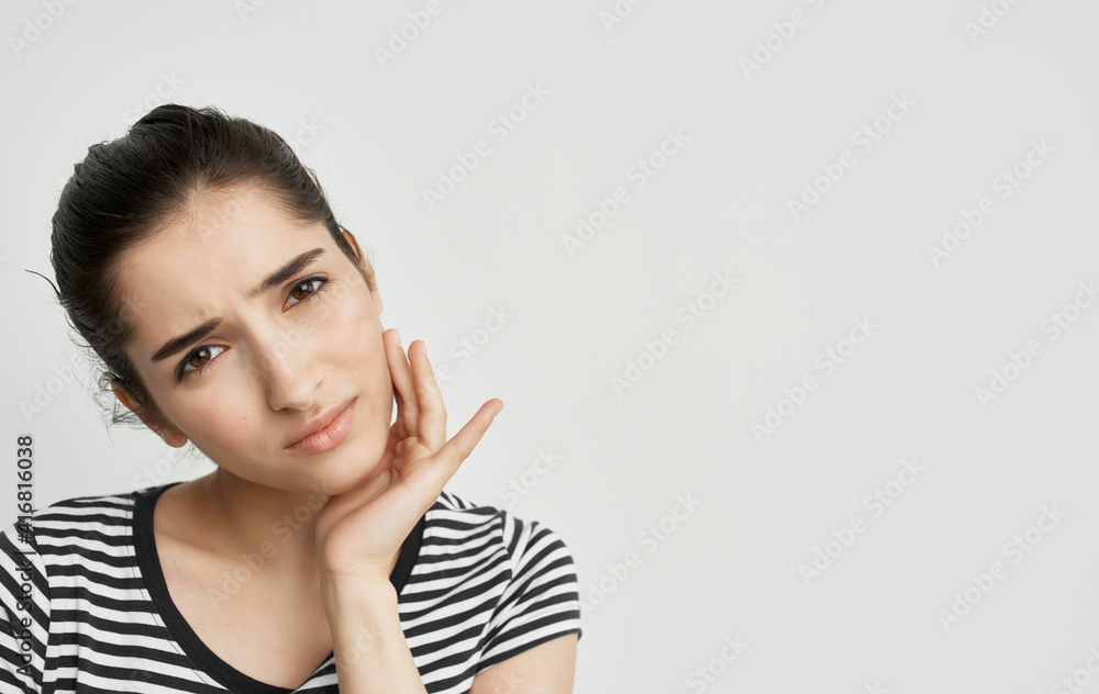 woman in striped t-shirt holding face dental problems pain discontent woman in striped t-shirt holding face dental problems pain discontent