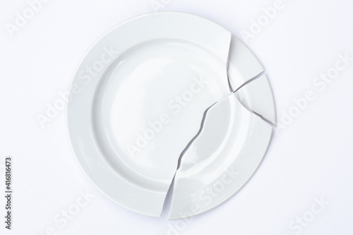 shards of a broken white plate stacked together on a white background. The concept of breaking up relations, divorce, destruction