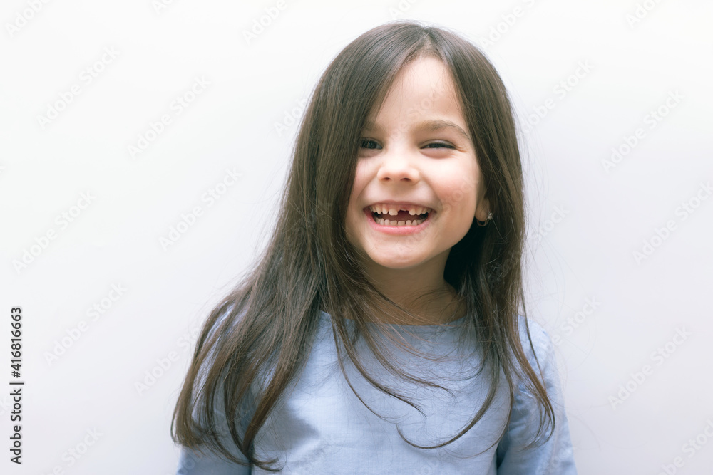 Cheerful laughing little girl with long hair without a tooth on a white background Cheerful laughing little girl with long hair without a tooth on a white background