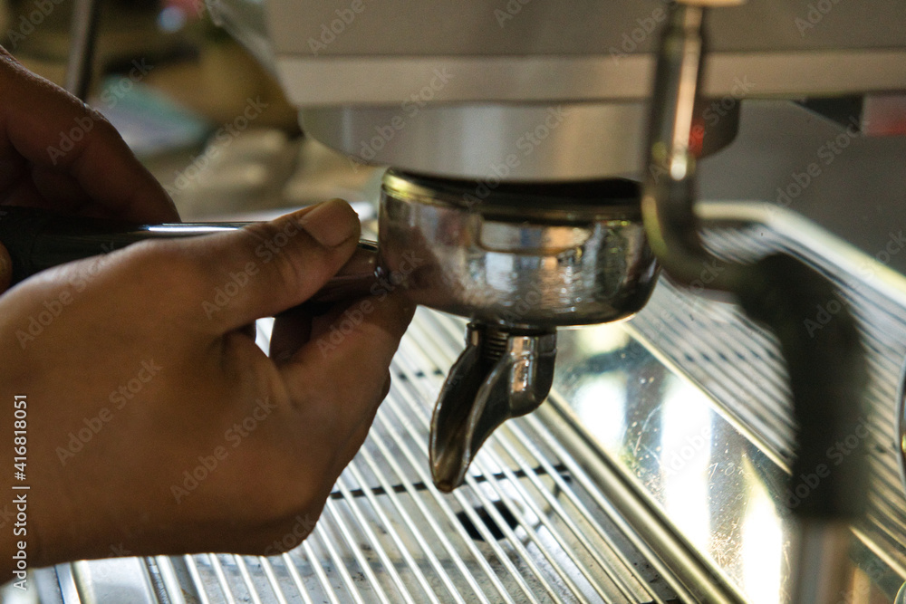Asian men's hands making coffee from a machine
