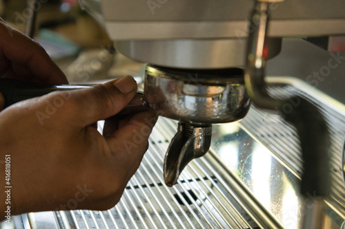 Asian men's hands making coffee from a machine